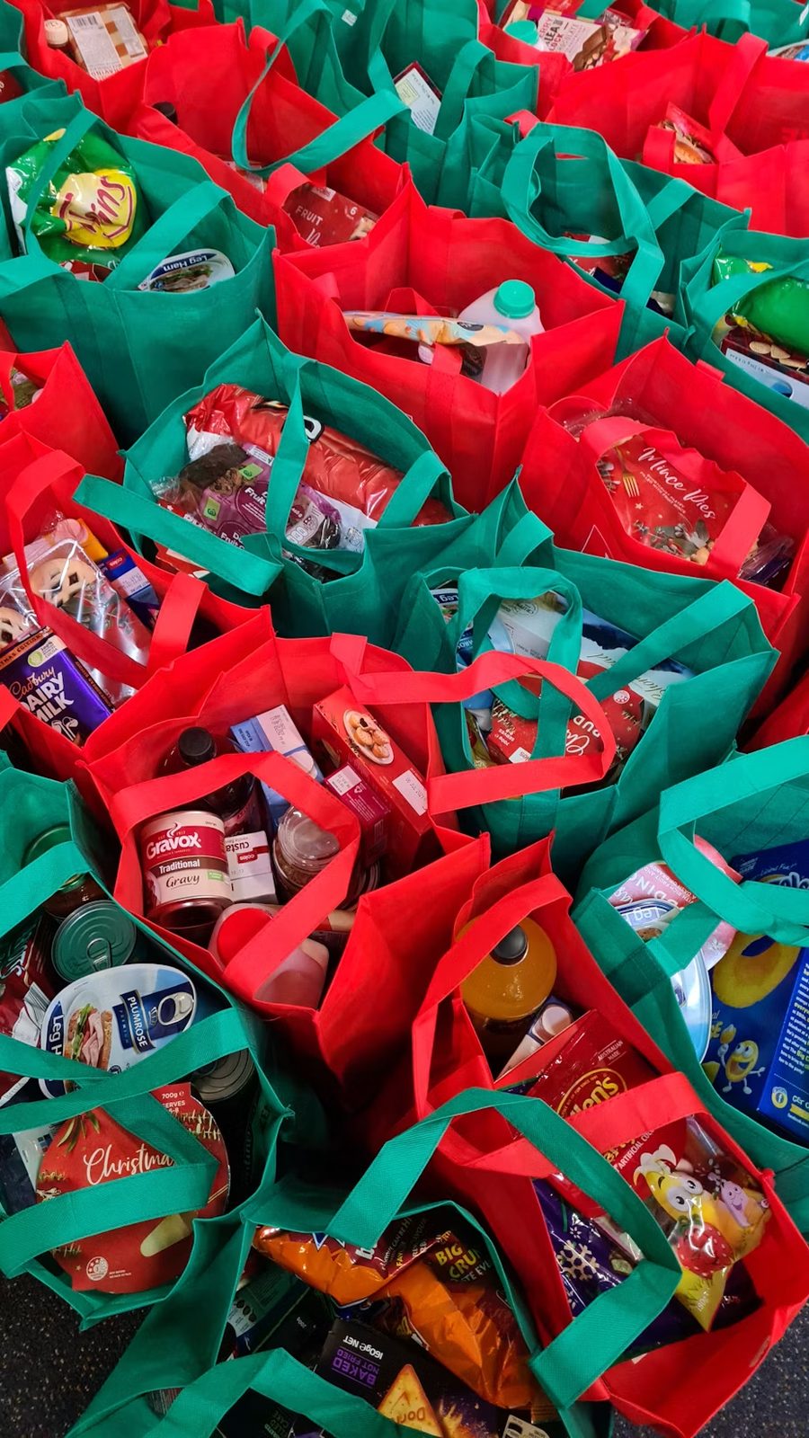 Bulk Christmas hamper bags packed with food, treats and groceries for a community drive